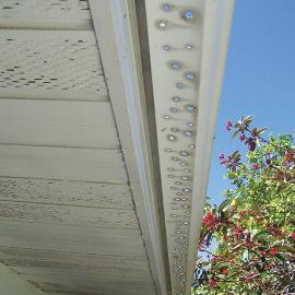 This gutter wouldn't drain properly because it was sloped incorrectly. Instead of lowering the end with the downspout a few inches, they drilled hundreds of holes, thus defeating the purpose of having a gutter at all.